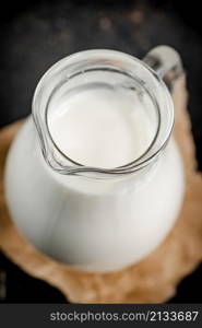 A full jug of fresh milk. On a black background. High quality photo. A full jug of fresh milk.