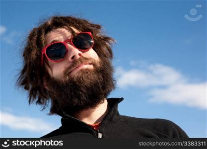A funny portrait of a male with a full beard and sunglasses