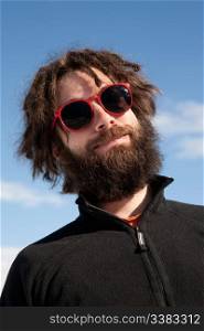 A funny portrait of a male with a full beard and sunglasses