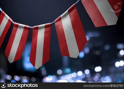 A garland of Austria national flags on an abstract blurred background.. A garland of Austria national flags on an abstract blurred background