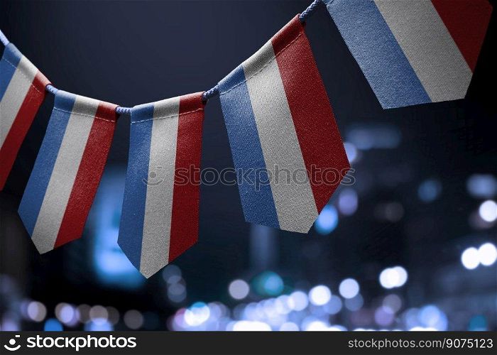 A garland of Netherlands national flags on an abstract blurred background.. A garland of Netherlands national flags on an abstract blurred background