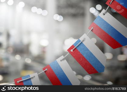 A garland of Russia national flags on an abstract blurred background.. A garland of Russia national flags on an abstract blurred background