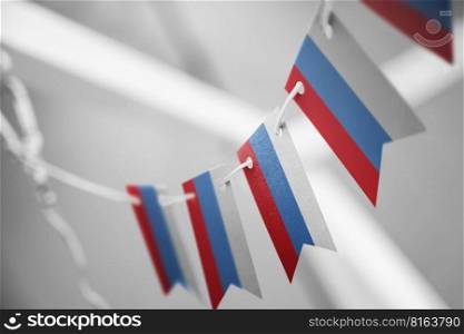 A garland of Russia national flags on an abstract blurred background.. A garland of Russia national flags on an abstract blurred background