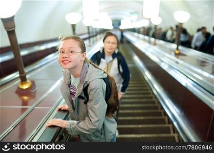 a girl (11 years) lifts on a metro escalator