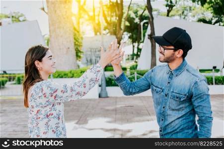 A girl and a guy shaking hands on the street. Two young smiling teenagers shaking hands in the street. Concept of man and woman shaking hands on the street.