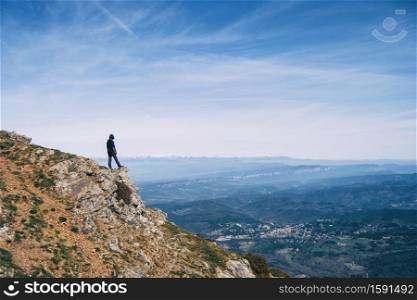 A girl contemplating the landscape from the top of a rock