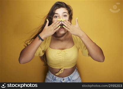 A girl expressing various emotions on her face under the yellow color, expression in the eyes, laughter with white teeth, grimace, joy of life and full of energy on her body.