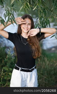 A girl in a black T-shirt and with a bag on willow alley.. A girl with long hair and wearing a black T-shirt with short shorts 3647.