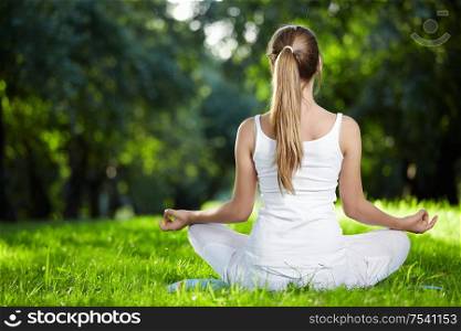 A girl in one of the yoga postures back outdoors