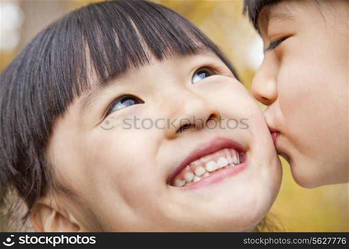 A girl kissing her older sister