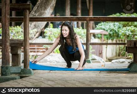 A girl laying out her yoga mat, woman spreading her yoga mat outdoors