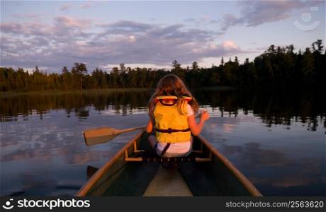 A girl paddling on Lake of the Woods in Canada