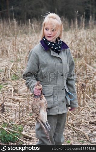 A girl picking up pheasants on a shoot
