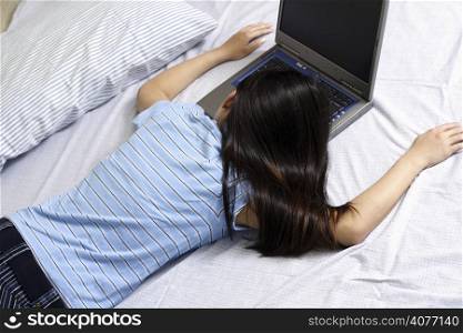 A girl resting on the bed after working with her laptop