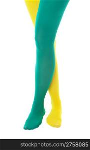 A girl showing team or school spirit by wearing a green and a yellow stocking. Shot on white background.