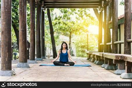 A girl sitting doing meditation yoga outdoors, Woman doing yoga outdoors, a young woman doing yoga with closed eyes.