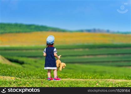 A girl standing on green grass.