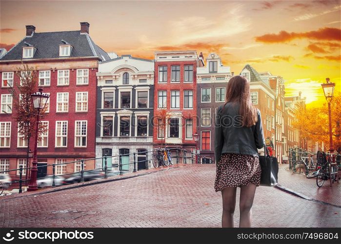 A girl walks through the old streets of Amsterdam