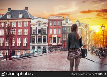 A girl walks through the old streets of Amsterdam