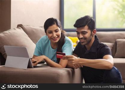 A girl with laptop and a boy with credit card shopping online. 