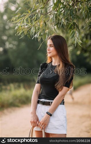 A girl with long hair and wearing a black T-shirt with short shorts.. A girl in a black T-shirt and with a bag on willow alley 3638.