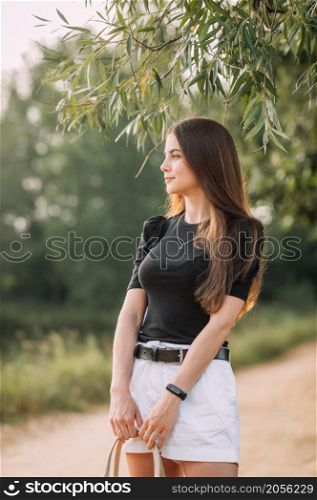 A girl with long hair and wearing a black T-shirt with short shorts.. A girl in a black T-shirt and with a bag on willow alley 3639.