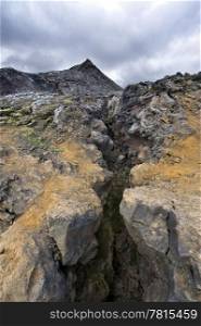 A glance in the volcanic Fissure of the 1984 eruption of the Krafla Volcanic system in Iceland. The solidified magma and lava is still hot, and provide a spectacular barren view