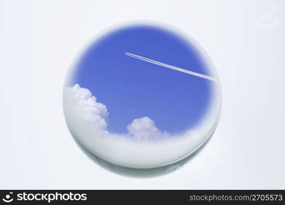 A glass ball with an image of a plane gliding through a blue sky
