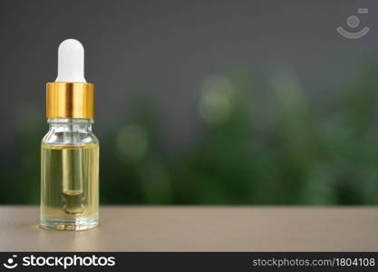 A glass bottle with dropper on the table. Concept of aroma oil, cosmetic, and beauty skin.
