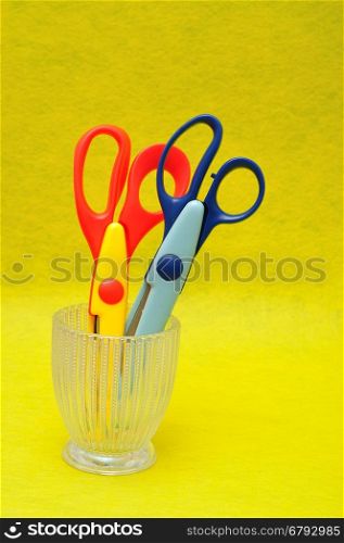 A glass container with scissors