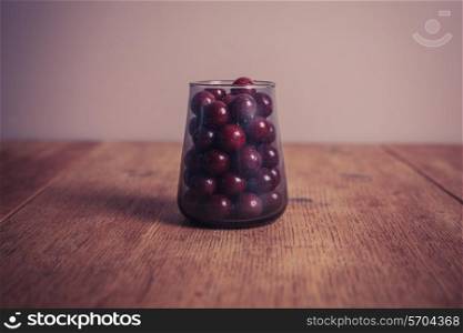 A glass conttainer filled with sugar coated purple sweet balls