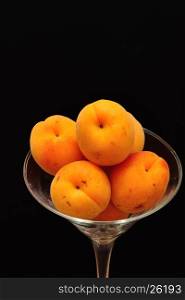 A glass filled with apricots