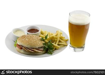 A glass of beer, a burger, french fries and sauce on a plate on an isolated background