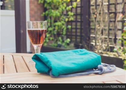 A glass of beer and an apron on a wooden table outside in a garden on a sunny day