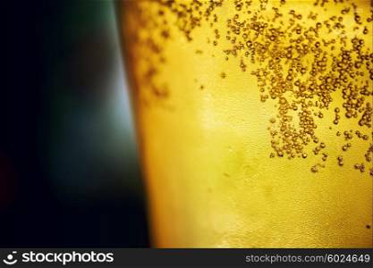 A glass of foamy golden beer closeup