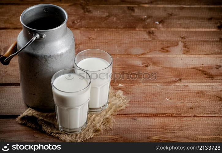 A glass of homemade village milk. On a wooden background. High quality photo. A glass of homemade village milk.