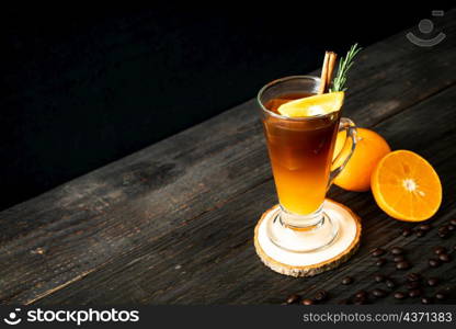 A glass of iced americano black coffee and layer of orange and lemon juice decorated with rosemary and cinnamon