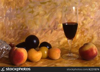 A glass of red wine with fruits on painted background