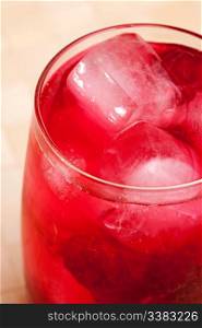 A glass of sparkling raspberry punch outdoors in a natural setting