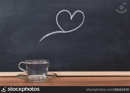A glass of water and a heart shape on the blackboard