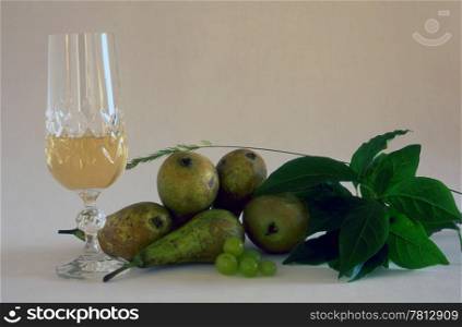 A glass of white wine and fruits isolated on white