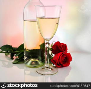 a glass of white wine with bottle and roses