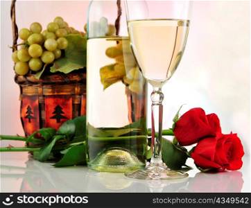 a glass of white wine with bottle and roses
