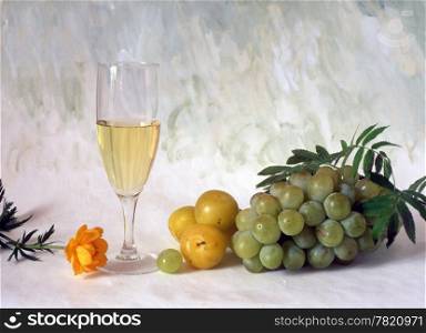 A glass of white wine with grapes isolated on painted background