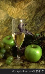 A glass of white wine with multi fruits on painted background