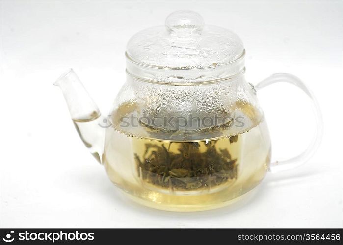 A glass tea pot with Flower Chinese tea isolated on a white background