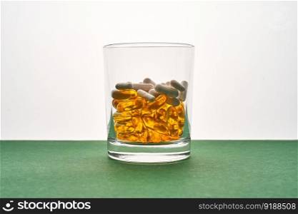 A glass with vitamins and other medical preparations.