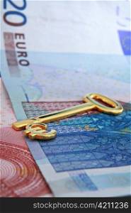 A gold key with the euro currency symbol lying on euro banknotes, a symbolic key to opportunity