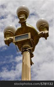 a gold street lamp and a cloudy sky in buenos aires argentina