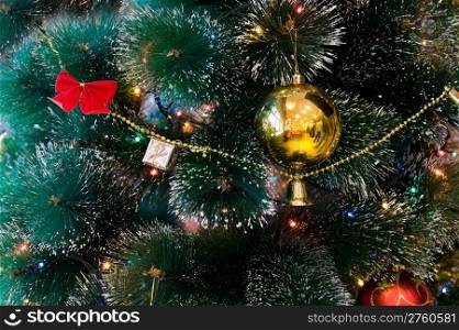 a golden ball and chain on a green christmas tree